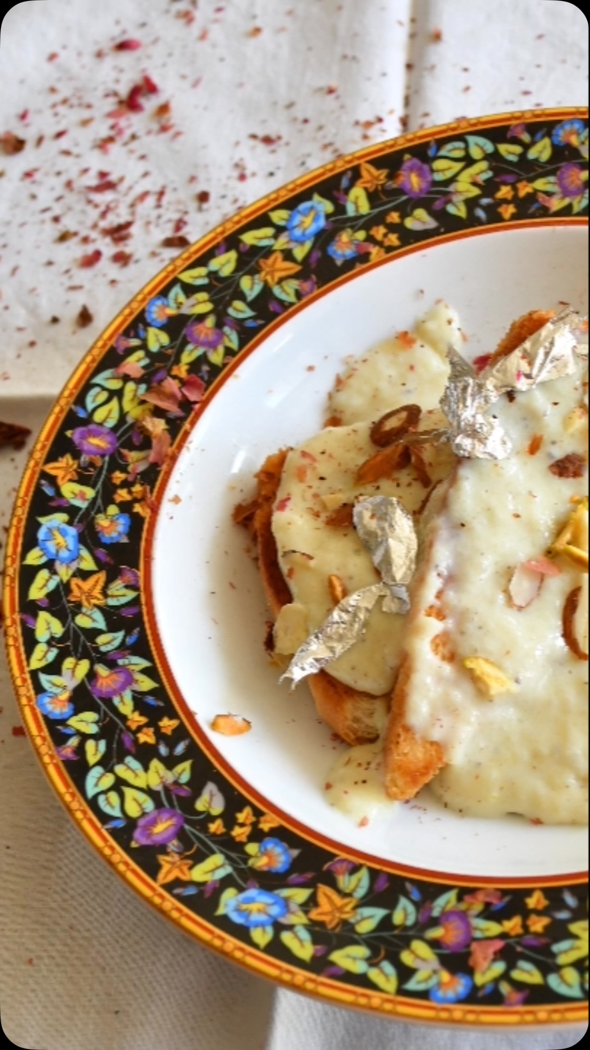 #doublkameetha #sweet#indianfood #This dessert is rich, tasty and very easy to make from common ingredients.  It is a bread pudding (Indian sweet of fried bread slices soaked in sweet condensed milk with spices, including saffron and cardamom). It has its roots in Awadhi cuisine and a similar dessert with roots from Hyderabad region. It is particularly prepared during the festive month of Ramadan and on Eid. 

Ingredients :
Makes 12 slices

6 slices of white bread (Cut into 12 triangles)
½  cup ghee (Clarified butter)
1 cup water 
½ cup sugar 
6 green crushed cardamom seeds, 
Few saffron threads 
2 cups indian condensed milk (Rabadi)
For Garnish - sliced mixed nuts (Pistachios and almonds) 
Optional - silver varak (Edible silver foil) 

Method 

Heat 2 tbsp ghee in a large, heavy bottomed fry pan and put on the medium heat.
Add as many bread triangles as possible in a single layer without overcrowding
Wait until the triangles are golden brown and crisp. 
Add 2 tbsp ghee and bake the other side of the bread
Transfer baked bread triangles to a plate and repeat the process with remaining breads. 
While the bread is baking,  combine water, cardamom, sugar and saffron in a medium saucepan and heat the mix till  it comes to a boil. Cook for additional 5-7 minutes till the sugar dissolves and the syrup becomes a little sticky. 
Keep the syrup warm.
Dip each fried bread triangle in the syrup for 2 to 3 seconds on each side.
Arrange the triangles on a serving platter. And add rabadi.
Garnish with pistachios, almonds and edible silver foil (Optional). 
Enjoy! More recipes on my website