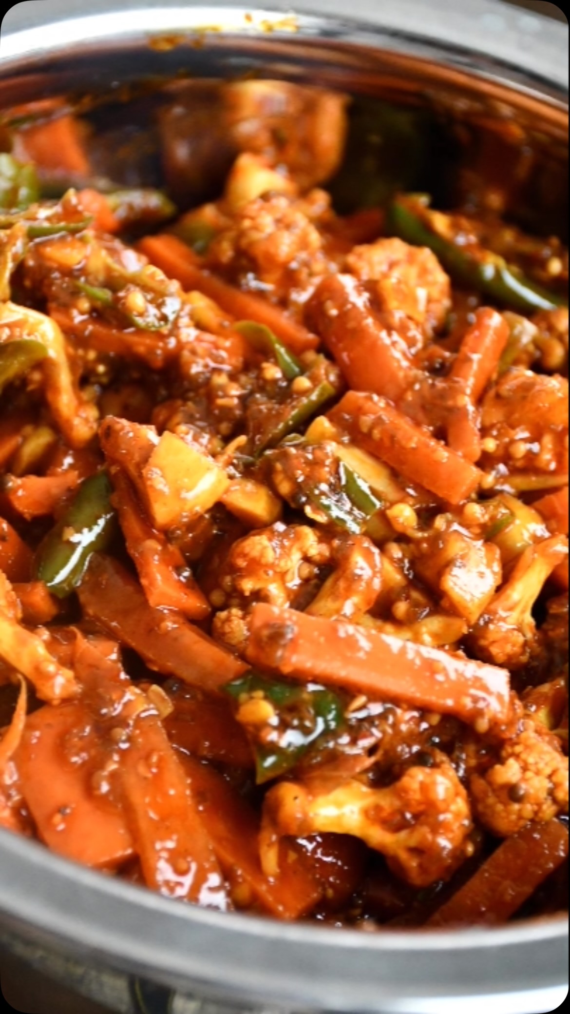 #gajar#gobhi#pickle#This is a seasonal pickle and is generally prepared in summer. I used carrots, green chili and cauliflower but additional vegetables like turnip, ginger,  garlic or any other crispy vegetable can be used. This can be made fast in small batches and consumed fresh. If you need to store for longer periods, it needs to be refrigerated.  It’s very tasty and can be served with any Indian food. Doesn’t matter when you want to eat or serve. 

Ingredients:
3 medium size carrots - washed and cut bite size and surface dried to get rid of moisture
½ cup cauliflower, washed and cut small size - dried to get rid of surface moisture 
4 green chilis, wash and cut bite size - dried to get rid of surface moisture
2 tsp amchoor (dry mango) powder
2 tbsp mustard seeds - crushed
2 tsp coriander powder
2 tsp fennel seed crushed
1 pinch hing/ asafoetida
2 tbsp red chilli powder
2 tsp turmeric powder
2 tsp methi seeds crushed
2 tbsp salt or to taste ( Reduce salt if you want to consume it in less than a week)
4 tbsp mustard/ sarson ka oil (or more if required) 

Method:
Take an airtight glass container, sterilize and keep aside.
Take a bowl and mix all dry ingredients.
Take a fry pan, add oil and heat it on low flame for 2 to 3 minutes.
Let it cool a bit and add all spices. Mix well so that oil is absorbed in spices.Now add carrots, green chillies and cauliflower. Mix very well and put in the glass container. 
Keep the container in sunlight for 5 day or more.
Achaar is ready! 
Enjoy!
