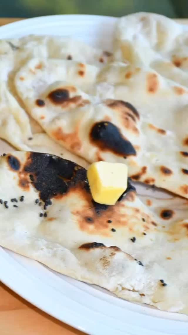 #butternaan😋 Naan, flatbread and a  must eat at an Indian restaurant is traditionally baked inside blazing-hot clay ovens (Tandoor). I am presenting a homemade version that  is actually quite easy to make on a hot skillet and stove top and is fluffy, crispy outside/ soft inside and very tasty 

Ingredients
Make 10 naan medium size 
3 cups +1/2 cups All purpose flour

Packet (8 gm)/ 2 ¼ tsp dry yeast
3/4 cup water lukewarm
1/2 cup plain yogurt (dahi) room temperature 
1 teaspoon sugar
1 teaspoon salt (or to taste)
3 tablespoon melted butter and more for naan on top
4 tablespoons kalonji (optional) 
Method
In a bowl, mix lukewarm water and sugar. Sprinkle the yeast on top.Keep aside and let it rise for about 10 minutes till it is bubbly.
Mix 3 cups of flour, salt, plain yogurt and melted butter in a big wide bowl. 
Add the yeast mixture. Mix and knead well to form a soft dough. Add water as required. 
Keep adding more flour if you find the dough too sticky or add additional water if the dough is hard. 
Knead for about 8-10 minutes till it is soft and non sticky
Put the dough in an oiled bowl and cover with a wet towel or cling wrap and place in a warm place.
Let the dough rise till it is double in volume (About two hours). 
Once the dough has doubled, remove the towel/ cling and punch the dough down.
Divide the dough into ten equal pieces.
Take each piece and form a ball. Flatten and roll into round flat bread shape (About 5 mm thick)
Sprinkle a bit of the kalonji on top of each naan and roll it in the dough.
Place the naan on a hot tawa/griddle. When they start to bubble, and the edges turn slightly brown, flip it and cook on the other side. 
Roast both sides on a flame (alternately, you can put it in toaster till it is slightly crispy)
Spread butter on the top and serve hot with Matar (Dry peas) curry or Chole (Chickpeas/ Garbanzo beans curry)or any curry.
Note: you can store it for about 1 week in the fridge. Whenever you need, roast it in the toaster and serve.