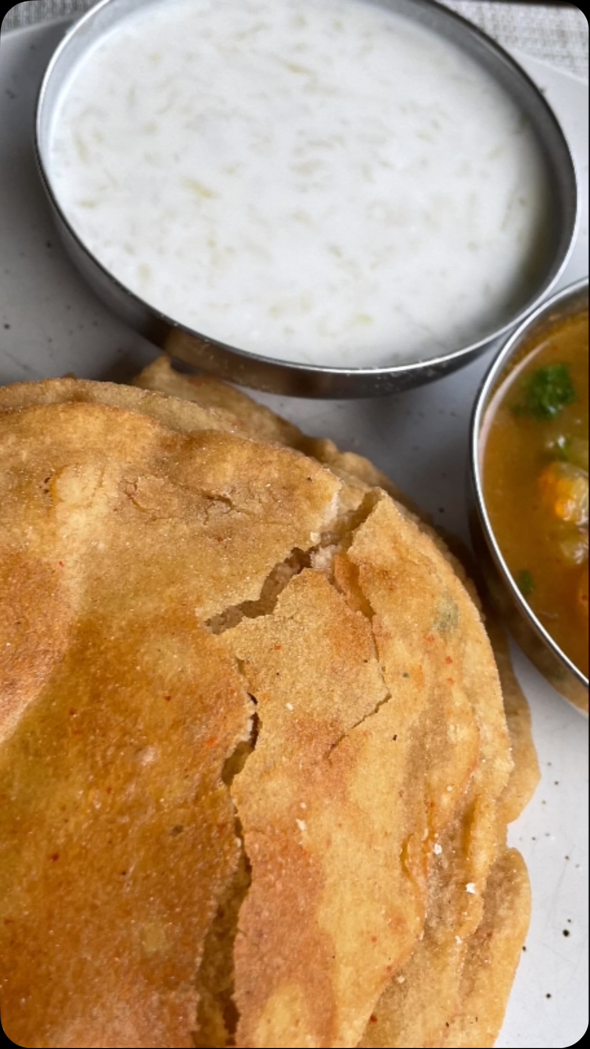 #During the celebrations of Navratri (and some other festivals), devotees fast. Throughout this fasting period, people consume #Kuttu (buckwheat). According to Hindu mythology, it is a strict NO for consuming grains during Navratri. Hence pseudo cereals such as kuttu or Singhara Ka atta(water caltrop/ chestnut) are consumed during this time. I have tried this recipe multiple times. It’s always so yummy.  It’s so simple and uses few ingredients we have in our  pantry.

Ingredients 
2 cups Kuttu (buckwheat)  or singhara (water caltrop) atta/  flour + ⅓ cup for dusting
3 medium potatoes boiled and mashed (fully mashed, not crushed) 
2 tsp black salt (or use any other salt) -  adjust to taste 
2 tsp black pepper - adjust  to taste 
 2 tbsp cilantro - finely chopped (optional) 
1 or 2 green chili finely chopped - adjust to taste (optional)
Oil for  deep frying
 

Method 
Take a wide bowl and add flour, potatoes, green chili, cilantro, salt and pepper.
Add about 1 tbsp oil and mix all ingredients 
Knead into a hard dough, add water as required and make a hard dough.
Apply oil on the dough surface, cover the dough and keep aside for about 5 minutes.
Add oil to a fry pan and put on medium-high heat
Apply oil to your palms and take a golf ball size piece of dough and roll it between palms
Spread flour dust on a flat surface and roll with a roller pin into a flatbread (Poori) about 3 inches in diameter. Apply flour dust as needed.
When oil is hot,  add poori and fry from both sides till golden brown.
Fry remaining pooris in the same manner. 
Serve with aloo sabji, chutney and dahi
Note: if the pooris break during frying,  add more flour to the dough and also make poori size smaller.
Some poori pop it  but some not because of cilantro and potatoes.
Very tasty and it is good for lunch and traveling.