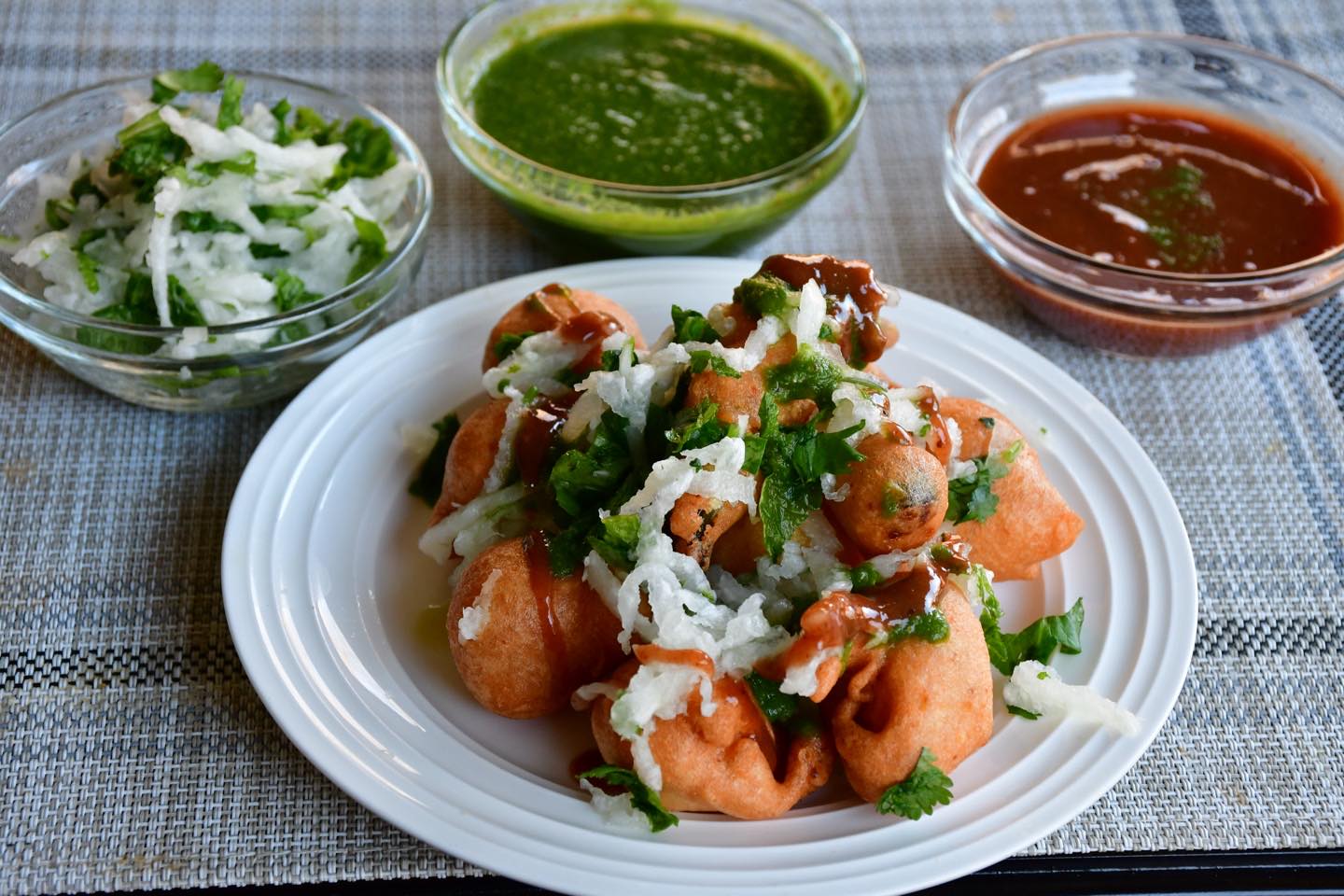 #moongdalramladdu#pakora#chaat (spicy street food)
ingredients :
Serves: 4 or more
I cup yellow moong dal
½ cup yellow chana dal
½ cup white urad dal
2-3 green chili
1 inch ginger
2 tsp red chili powder
2 tsp whole dry coriander seeds (optional)
1 tsp fennel seeds (optional)
Pinch of hing (asafoetida)
1 large mooli (Daikon/ Radish) grated
Lemon juice (1 lemon)
Oil for frying
Salt to taste
For chutney
1 cup coriander leaves
⅓ cup mint
2 green chili
½ tsp black pepper
½. inch ginger - chopped
1 tsp cumin seeds
1 inch of mooli (optional)
1 lemon juice
1 tsp sugar
Method for chutney:
Add all ingredients in the blender with ⅓ cup of water and make a paste. Add water, if required. Keep aside.
Method for pakoras:
Wash all dals (lentils) under running water and soak for about 7 to 8 hours.
Add lentils, hing,whole coriander(optional), red chili powder, green chili, ginger to the blender (Use processor, if you have one) and make a paste.
Heat oil in a frying pan (medium heat)
Meanwhile mix the dal batter using your hands for about 5 minutes to make it fluffy (Air in the mix makes pakoras crisp & soft and consumes less oil). Add fennel seeds and salt.
Now take a chunk of the mix (Use hands or a spoon) and drop it in hot oil and make pakoras. Fry on medium heat till golden brown. Do not overcrowd by putting too many pakoras together. Stir often.
Transfer on paper towels to soak excess oil. Repeat till you consume dal batter.
Take a bowl, add grated radish(mooli), salt and lemon juice. If you like, you can add chopped radish/ mooli leaves also. Keep aside
For serving, take a plate, add radish/ mooli mix, put 4-6 hot pakoras on top. Serve with green chutney on the side.
Enjoy this month watering recipe.
Note : You can also add green chili pakora. For this, take any variety of chill, cut vertically in the center, dip in the dal batter and fry. Serve with dal pakoras (4-6 dal pakoras/ 1-2 green chilli