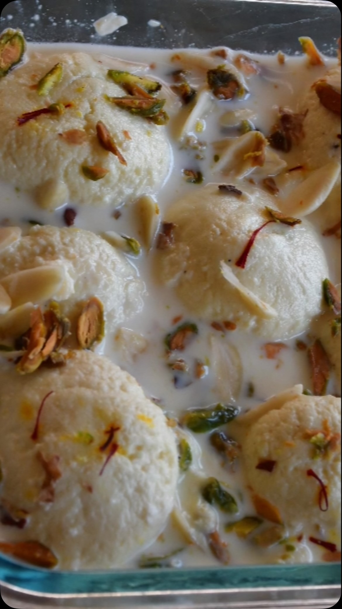 #I love this dish; it’s often served at #weddings and other #special occasions. It’s similar to rasgulla, which I’ve posted before, but here thick milk is also used. They’re quite easy to make, and paying attention to detail - like remembering to knead but not over-knead - will make them even better. Try this #mouthwatering recipe#full recipes on my website 

Serves: 4 to 5

Ingredients:
4 cups whole milk, if possible use cows milk (A2 milk)
3 tbsp lemon juice
1 ½  to 2 cups sugar (as per taste) 
½ tsp rose essence
½ tsp cardamom powder
For garnish: pistachio and saffron 

For thickened milk 
3 cups whole milk
1 tsp cardamom powder 
Few drops rose essence

Method:
Boil the milk on medium heat, then let it cool a bit (3-4 minutes).
While the milk is cooling, mix equal parts of lemon juice and water and keep aside.
Add 2 tbsp of the lemon juice mix to milk and stir. Start on low heat and add 2 more tbsp lemon juice, then stir. If the milk does not separate, add the remaining lemon mix. Keep going until the milk separates/you see chenna (curd).
Take a muslin cloth and strain the water from the separated milk and wash under running water so that the tartness from the lemon juice is gone.
Squeeze the water out, then make a knot on muslin cloth (with the curdled milk inside) and hang for about 20 minutes to drain out the excess water.
Remove from the cloth and spread on a cutting board. Knead with your wrist for about 8 to 10 minutes or until it becomes smooth. 
Make round balls (About ¾ inch diameter), making sure there are no cracks. Keep aside.
Add 4 cups of water and sugar to a pressure cooker (or fry pan). Heat on medium till it starts boiling.
Lower the heat and gently add the balls to the boiling sugar syrup. Add rose essence and cardamom powder.
Close the lid and let it simmer for about 10-12 minutes. Stir often.
Check in between and the balls should become almost double in size. Close the heat and keep aside.