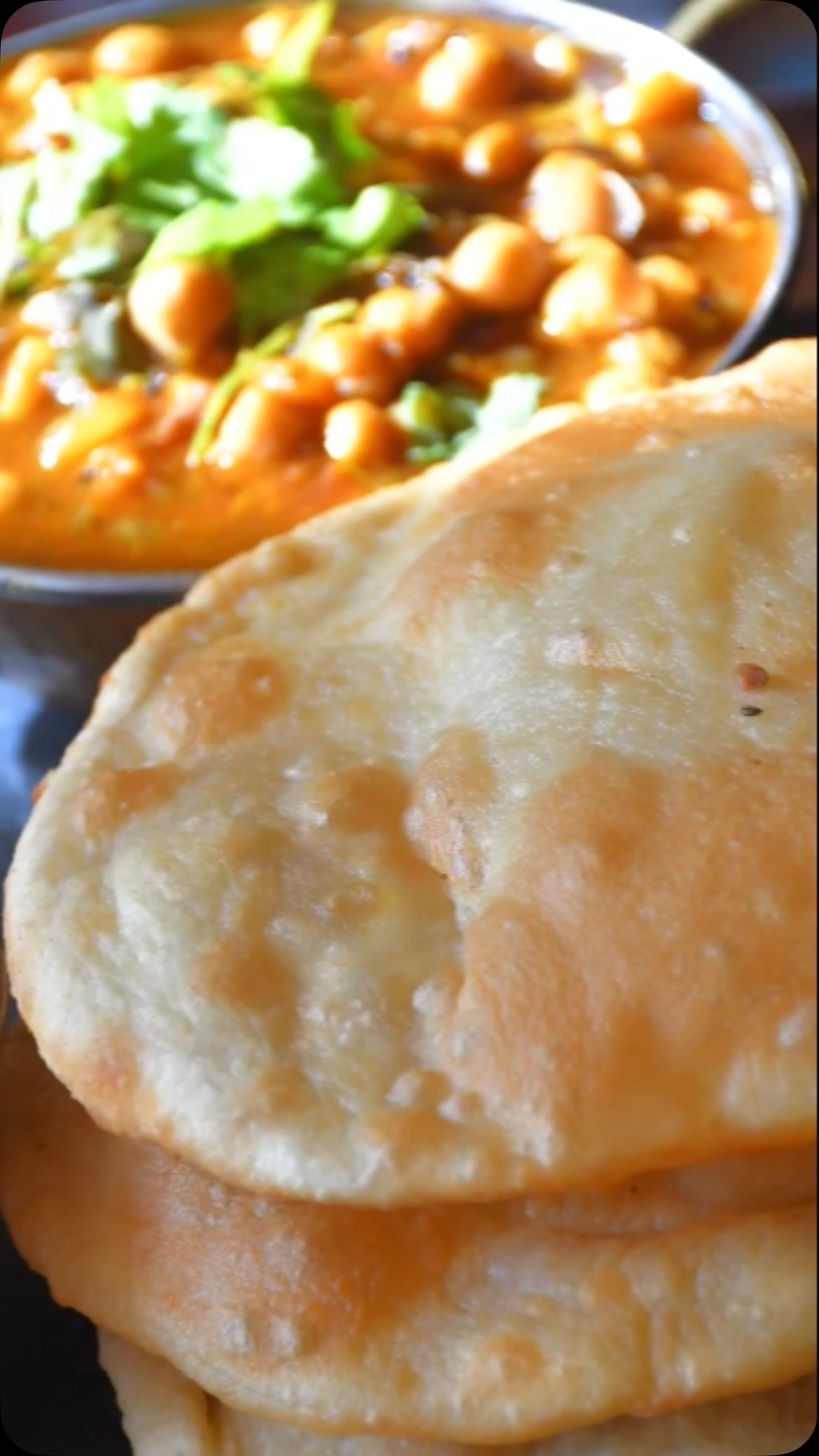 #bhatura##Bhaturas are like #naan, but they’re a little different because while naan is baked in an oven, bhaturas are #deep fried. However, both are absolutely delicious! 

Ingredients
 
Make 7 to 8 
2 cups all purpose flour ½ cup for dusting 
1/2 cup sour yogurt (dahi) or more if required 
Salt to taste or 1 tsp 
 oil for frying 
½  tsp baking soda ( optional)

Method

Mix flour, salt, and yogurt to make a dough. If required, add water; the dough should be a little hard. Spread a little oil on the dough. Put the dough in a box and put the lid on. Keep in a warm place such as the oven to ferment for about 7-8 hours. If the weather is cold, then it needs 10 hours. I’d recommend doing this either overnight so you can have the bhaturas for lunch, or throughout the day so you can have them for dinner.

Now, put a fry pan on the stove and add oil. Take the dough and split into equal parts. Spread oil on the dough, and roll it out to have a 5-6 inch diameter, like a medium sized tortilla.

When the oil is heated, roast the bhaturas on both sides, until golden brown. Cook all in the same manner.

Serve with chole!