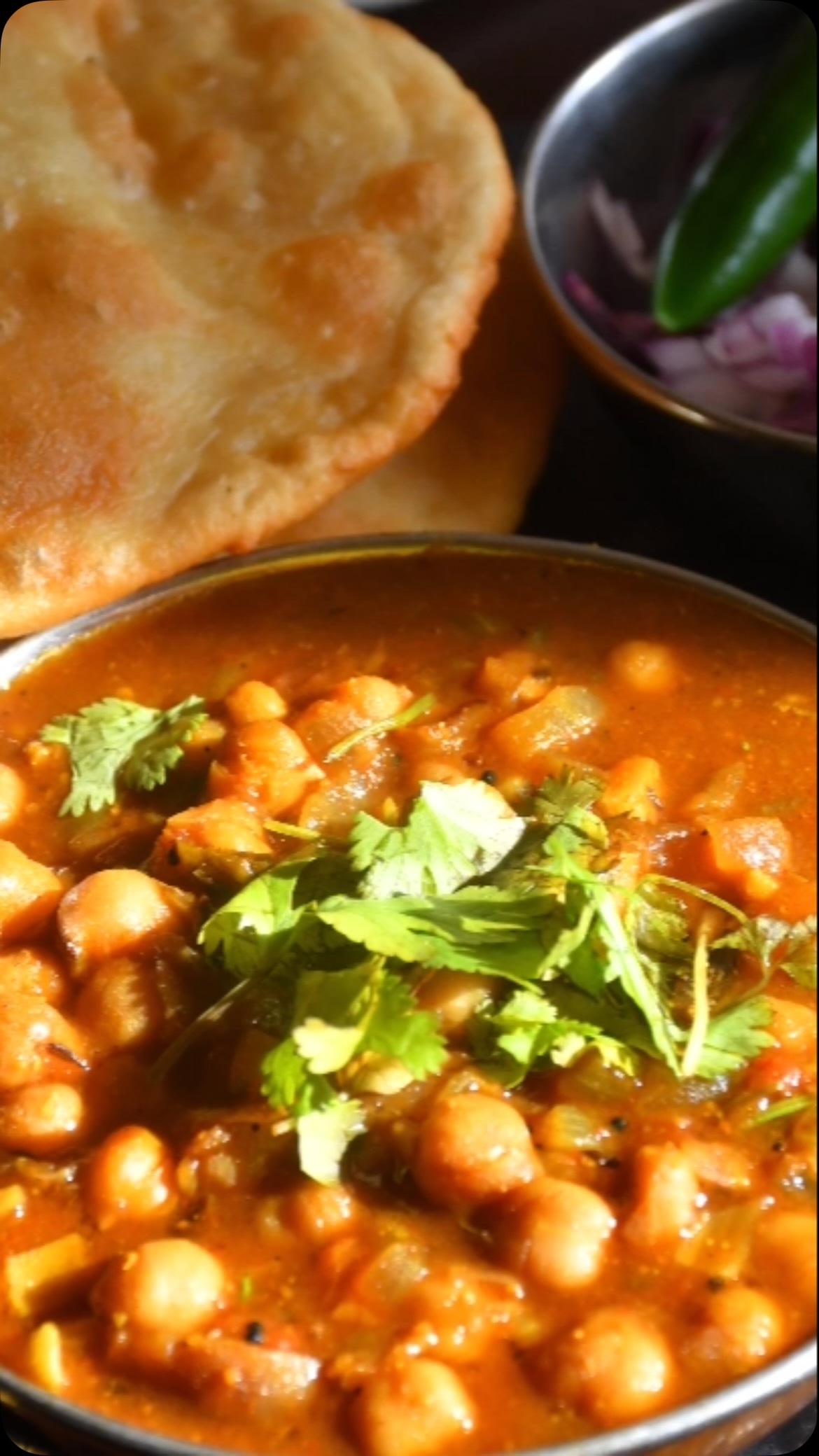 #masalachanarecipe #Punjabi chole masala or chana masala is one of the most popular curry dishes from Northern India made by cooking chickpeas with onions, tomatoes and lots of spices. 
In Northern India, no wedding or party is complete until you have chole masala on the menu. It is the heart of one of the popular dishes from Northern India called ‘Chola - Bhatura. This dish is liked by children, adults and elderly as well. It is full of protein & fiber and is quite healthy and easy to make.
I hope you like it.
Ingredients
Serves 4 
2 cups kabuli chana (Chickpeas/ Garbanzo)
1 medium onion - finely chopped
2 medium tomatoes -  finely chopped
2 green chillies - finely chopped
2 tsp ginger- grated
2 tsp garlic - crushed
1 tsp imli pulp
1 tsp cumin seed
½ tsp hing
2 tbsp channa masala
2 tsp red chilli powder
2 tbsp oil
2 or 3 cloves , rosht and crushed 
1 tsp cinnamon powder
1 tsp anardana powder
2 tsp coriander leaves finely-chopped 
1 lemon 
Salt to taste

Method
Rinse choley and soak for about  6 to 8 hours. Add soaked choley to a pressure cooker  with 5 cups of water, salt, clove and hing.
Put the pressure cooker on medium heat and let it cook till  6-8 whistles (About 30 minutes in an instant pot). Keep the cooker lid closed until it cools down.
Check the tenderness of the choley and if 
not tender, cook for a few more minutes till tender. Remember if choley is not tender and if you add gravy, it will never get tender.
Take a potato crusher (or serving spoon) and crush the boiled choley a bit (Do not overcrush). 
Seasoning
Take a frying pan, add oil and put on medium heat. When oil is hot, add cumin seed and let it crackle
Add chopped onions and a little bit of salt and cook till onions are golden in color. 
Add chopped tomatoes, green chilli, ginger, garlic, red chilly powder and imli pulp. Stir for about 2 to 3 minute and mix everything into a thick gravy.
Add chana masala and anardana powder to 
Add chana masala and anardana powder to the gravy and mix. Add the gravy to the choley and cook with the lid closed on medium heat for about 10 to 15 minutes. Check for consistency and it should not be too watery. 
Take a pan and heat 1 tsp ghee (clarified butter)