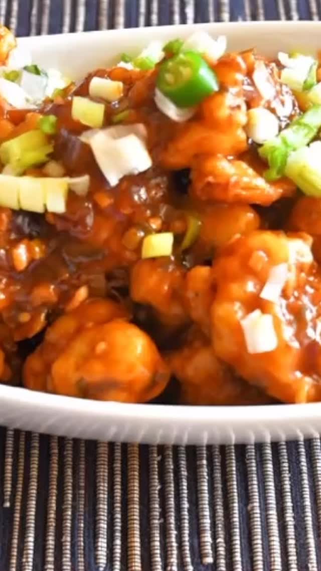 #gobhemancuren#Here is an Indo-Chinese version of preparing (Cauliflower) called Gobhi manchurian. It is a very delicious recipe and surprisingly not very difficult to make. When you serve and eat, it is worth all the effort.

Ingredients: 
Serves: 4 or more 

1 medium cauliflower -  cut into small florets (~1 sq inch) 
5 tbsp all purpose flour 
5 tbsp cornstarch
2 tsp salt (Adjust to taste) plus additional for flour mix 
Oil for frying 
For the sauce:
3 tbsp oil
3 tbsp garlic - finely chopped 
2 green chilies -  finely chopped (adjust to taste) 
1 medium onion - finely chopped I cup water
Spring onion - for sauce as well as for garnish

METHOD 
For gobhi 
 Take a pot and add  4 cups of water with 2 tsp salt, wait until water starts boiling.
Add gobhi, and boil for about 3 or 4 minutes on medium heat.
Strain gobhi and let it sit for 3 to 5 minutes. 
Take a bowl, and add corn flour, all purpose flour,  salt to taste and make a thick paste (with consistency similar to tomato ketchup) . 
Heat the oil in a  frying pan on medium heat. 
Dip gobhi florets into flour  mix and coat it fully. Fry one or two florets into hot oil and check to make sure that flour mixture is not separated from florets. If it does, add 1 tsp all purpose flour,  1 tsp cornstarch and salt (If required, add additional flour) into the flour mix to make it thicker. 
Fry all of the florets (till golden in color) and keep aside.
Optionally, to make gobhi florets crispier, fry it once till semi fried. Let it cool and fry it again on high flame till golden in color.
For the sauce
Take a wok and add oil, wait until hot then put garlic, onion, green chillies and add a little bit of salt.
After about a minute, add soya sauce, red chilli paste and ketchup, stir in the pan. 
Now add spring onions
Add 1 cup water. 
Take a small bowl, mix  2 tsp cornstarch mix in 3 tsp of  water and add to the wok
Stir till it becomes thick (tomato ketchup like consistency). If required, add more cornstarch or water as necessary. Put off the flame.
Take a big serving bowl, add fried gobhi then sauce and garnish for spring onions. Serve immediately