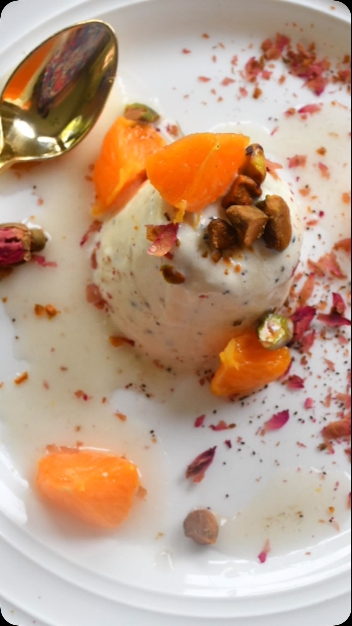 This dessert is extremely beautiful and elegant, bursting with different flavors like vanilla, cardamom, and rose water. It’s delicious, and perfect for the summer#carodomom #kulfi #ice cream#delicious 

Ingredients:
Serves: 6
2½ cup heavy cream 
1 cup whole milk
1 tsp vanilla essence
2 tsp cardamom powder
⅓ cup sugar
Pinch of salt

For the topping
2 oranges or 1 grapefruit 
⅓ cup sugar
⅓ cup water
1 inch ginger, sliced
½ tsp rose water

Garnish
Roasted pistachios, chopped
Dried rose petals

Method:
Take a heavy fry pan and add milk, cream, and cardamom powder and put on slow heat. 
Let simmer for about 30 minutes or until the milk mixture is halved. 
Add sugar and mix.
Wait until the sugar dissolves, then add vanilla essence and salt. Mix and turn off the heat.
Now wait until the milk mixture comes to room temperature.
Take a mold and add the milk mixture and put in the fridge for about 24 hours.

For the citrus fruit:
Add sugar and water to a pan with sliced ginger and put on medium heat.
Wait until sugar dissolves and syrup thickens slightly.
Strain the syrup and remove the ginger. Keep aside.
Peel the orange or grapefruit cut into pieces and add rose water. Keep aside.
To serve, take a plate and pour sugar syrup onto it. Put the ice cream in the center, and top off pistachio, orange, and rose petals.
Enjoy!