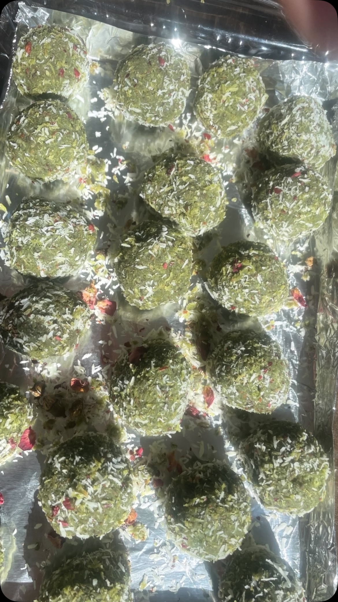 #paanladdu#Paan Laddu is a #delicious#, elegant, quick and rich #dessert made with Paan leaves, gulkand, condensed milk and coconut. Fresh Paan leaves and gulkand provides an authentic paan flavor and will wow your guests.

Ingredients 
Serves 8
½  cup condensed milk
4 paan leaves
1-1/2 cup coconut powder 
⅓ cup Gulkand 
Nuts (optional)
Rose Petals 
Ghee 
Food color - Green 

Method 
Add condensed milk and paan into a food processor or grinder and grind for about 2 minutes till leaves are crushed (Do not make a paste)
Add 2 or 3 drops of green color and turn the grinder for a few seconds to mix. Keep aside.
Put a pan on slow heat and add 1 tbsp ghee. Add 1 cup coconut powder when the ghee has melted. Keep stirring and roast for about 1 minute on very low heat otherwise the coconut will burn. Keep aside.
Put another pan on slow heat and add condensed milk, paan mixture and mix until thick (about 3 to 5 minutes). Remove from heat.
Add roasted coconut into the condensed milk- paan mixture and mix well to make a dough. 
Mix ½ cup coconut and 2 tbsp rose petals in a bowl and keep aside. 
Divide paan mixture and divide into 8 equal parts. Take a part and roll it into a flat disc about 2 inch diameter using your palm. Add 1⁄2 tsp gulkand and nuts, if desired. 
Roll in your palms to make a laddu. Roll into coconut - rose petal mixture and  keep it on a plate. 
Repeat to make the rest of the laddus and keep in the fridge for about ½ hour.
To serve, sprinkle coconut and rose Petals on top!

Note: You can cut laddu into 2 or 4 parts and serve.
It will be tastier if you make it on the previous day and serve the next day.
See similar recipes on my cookbook on Amazon